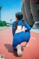 A woman in a blue and white outfit crouching on a track.