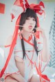 A woman in a red and white outfit holding chopsticks.