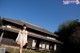 A woman in a bikini standing in front of a house.