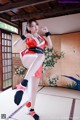 A woman in a red and white outfit is posing for a picture.