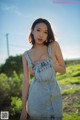 A woman in a denim dress posing for a picture.