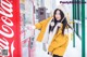 A woman standing next to a vending machine in the snow.