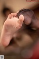 A close up of a baby's foot being held by its mother.