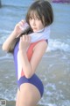 A woman in a bathing suit standing on the beach.