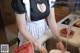 A woman in a maid outfit is washing a watermelon.