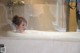 A woman taking a bath in a bathtub in a bathroom.