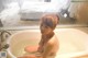 A naked woman sitting in a bathtub in a bathroom.