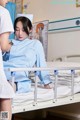 A woman in a hospital bed with a nurse standing next to her.