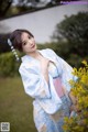 A woman in a blue and white kimono posing for a picture.