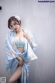 A woman in a blue and white kimono posing for a picture.