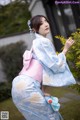 A woman in a blue and pink hanbok is posing for a picture.