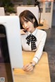 A woman sitting at a desk in front of a computer.