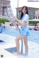 A woman in a blue and white uniform standing in a pool.