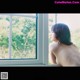 A naked woman looking out of a window.