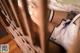 A woman laying on top of a bed next to a wooden fence.