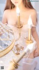 A woman in a white dress holding a chandelier.