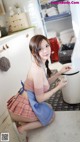 A woman in a blue and white apron is cleaning a kitchen.