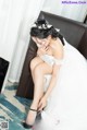 A woman in a wedding dress sitting on a couch.