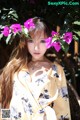 A woman in a yellow kimono with flowers in her hair.