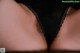 A close up of a woman's butt in a black thong.