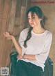 A woman sitting on top of a chair next to a wall.