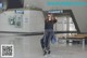 A woman walking through an airport with a suitcase.