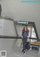 A woman walking through an airport with a black bag.