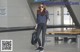 A woman in a plaid shirt and black pants is walking through an airport.