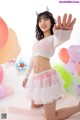 A woman in a white sweater and pink tutu posing for a picture.