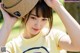 A young woman wearing a straw hat and a yellow shirt.