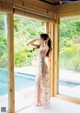 A woman standing in front of a sliding glass door.