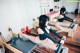 A group of women doing pilates on reformers in a gym.