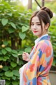 A woman in a colorful kimono holding a tassel.